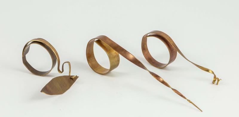 Unusual copper rings displayed on a white background.