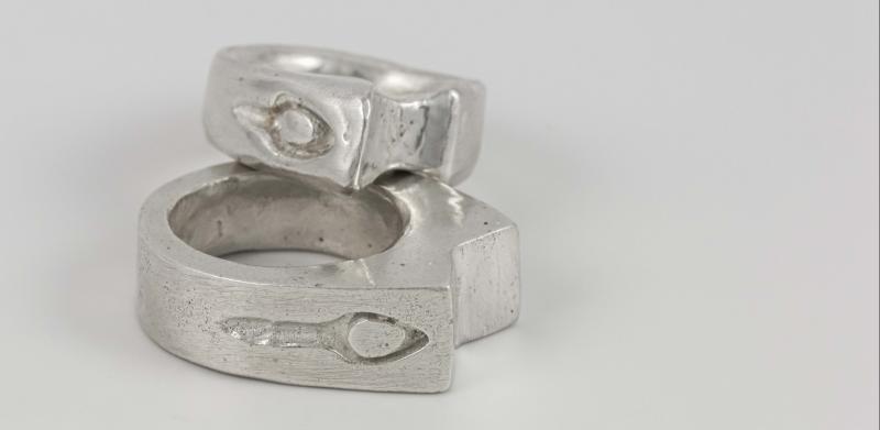 Two stacked silver rings with an etched symbols.