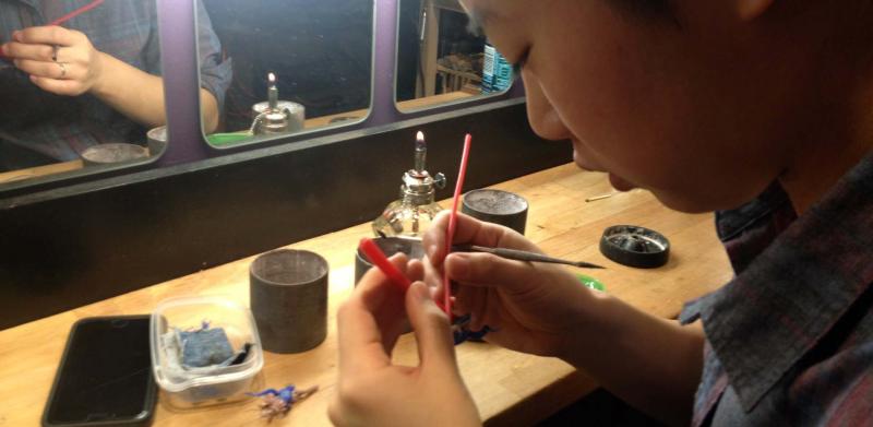 A woman working with wax in a jewelry studio