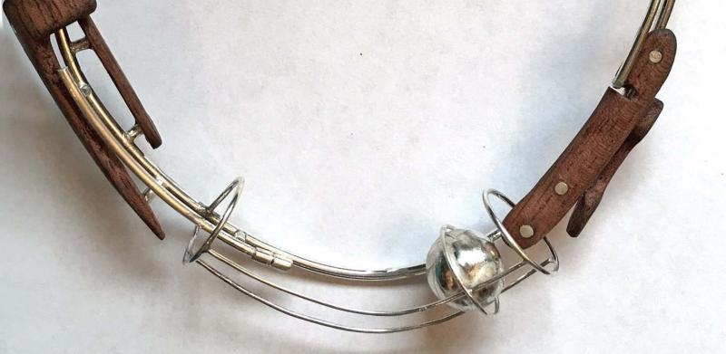 A silver necklace with dark wood accents and a small spherical pendant.