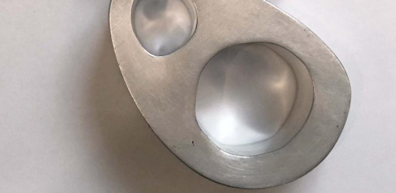 Photograph of a silver-toned, abstract pendant with two circular cutouts on a black cord.
