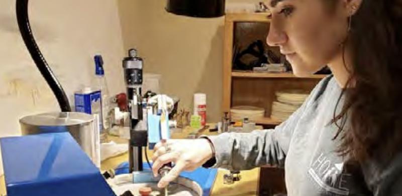Photograph of a woman using a rotary tool in a workshop.