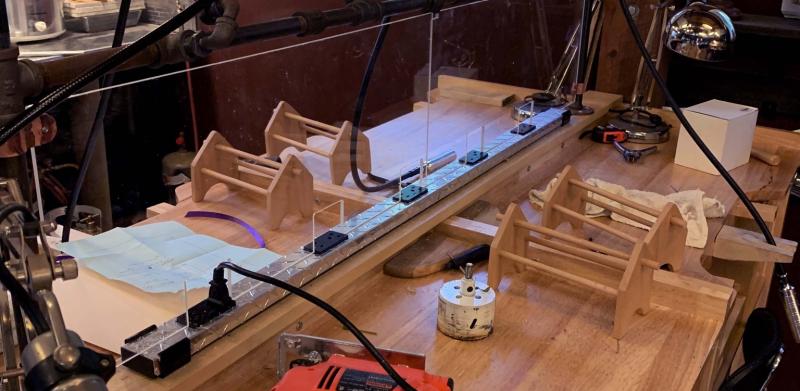 Photograph of a workshop bench with tools, wooden crafts, and hanging lights.