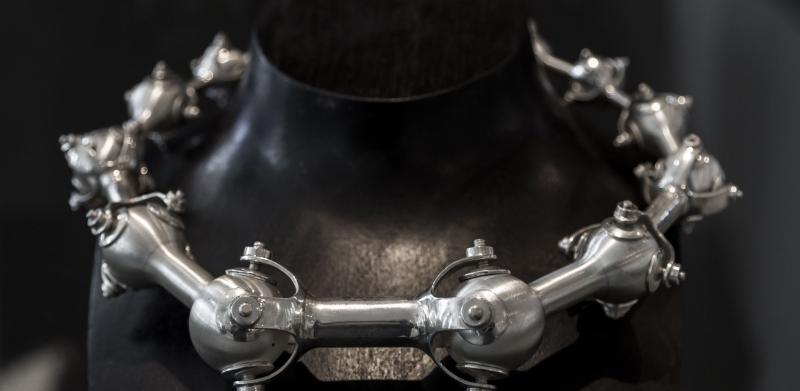 Photograph of a silver spiked necklace on a black mannequin.