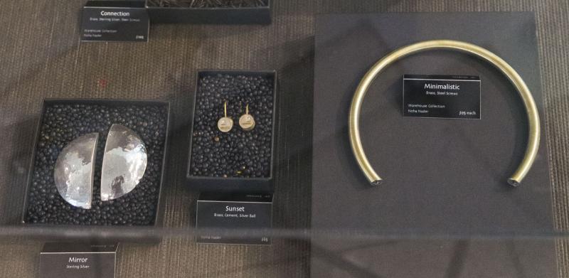 Photograph of jewelry pieces displayed inside a glass showcase.