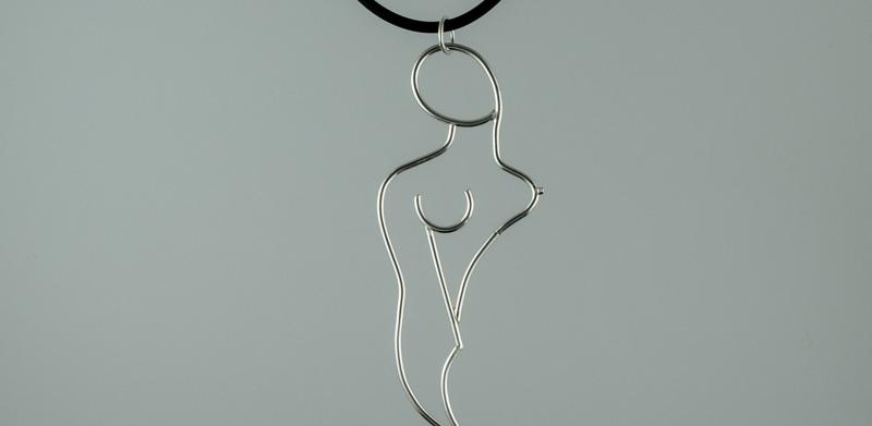 Photograph of a wire pendant of a woman's figure on a black cord.