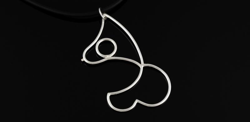 Photograph of a minimalist silver wire pendant shaped like a female form on a black cord.