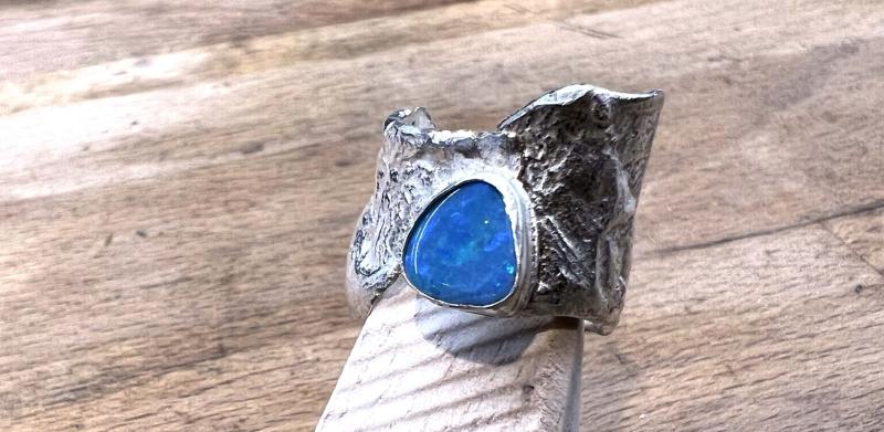 Photograph of a silver ring with a blue opal