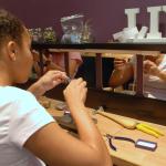 A young girl working on a jewelry project