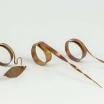 Unusual copper rings displayed on a white background.