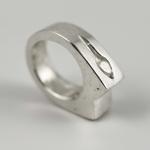 Photograph of a silver ring with a carved design.