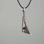 Photograph of an abstract silver pendant with a small dark gem on a black cord.