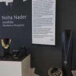 A jewelry exhibition display by Noha Nader featuring artist statements and necklaces.