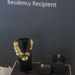 A display of jewelry by Noha Nader featuring gold necklaces and earrings.