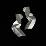 Photograph of two abstract silver earrings against a black background.