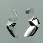 Photograph of two abstract silver metallic geometric earrings on a solid grey background.