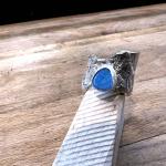 Photograph of a silver ring with a blue opal